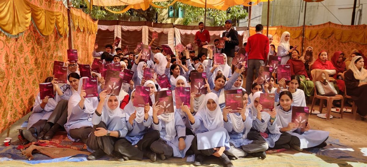 Student group holding admission brochures after an outreach session